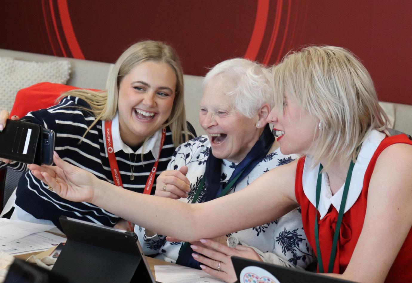 Two young people helping an elderly person